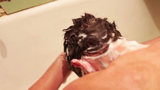 Man washes his hair
