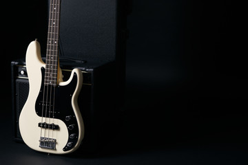 Obraz na płótnie Canvas Black and white electric bass guitar with amplifier,hard case on black background with copy space.