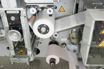 factory and equipment for the production of female sanitary napkins. women hygiene pads on a...