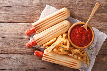 Grilled hot dog rolls with French fries and tomato sauce close-up. horizontal top view
