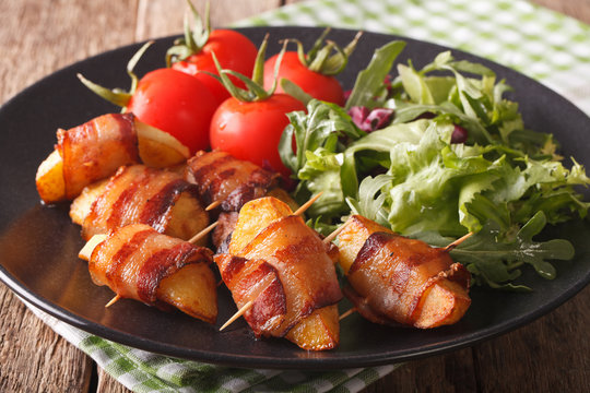 Grilled potato wedges with bacon and salad mix close-up. horizontal