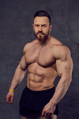 Fototapeta na wymiar Shirtless bearded bodybuilder over grey background.