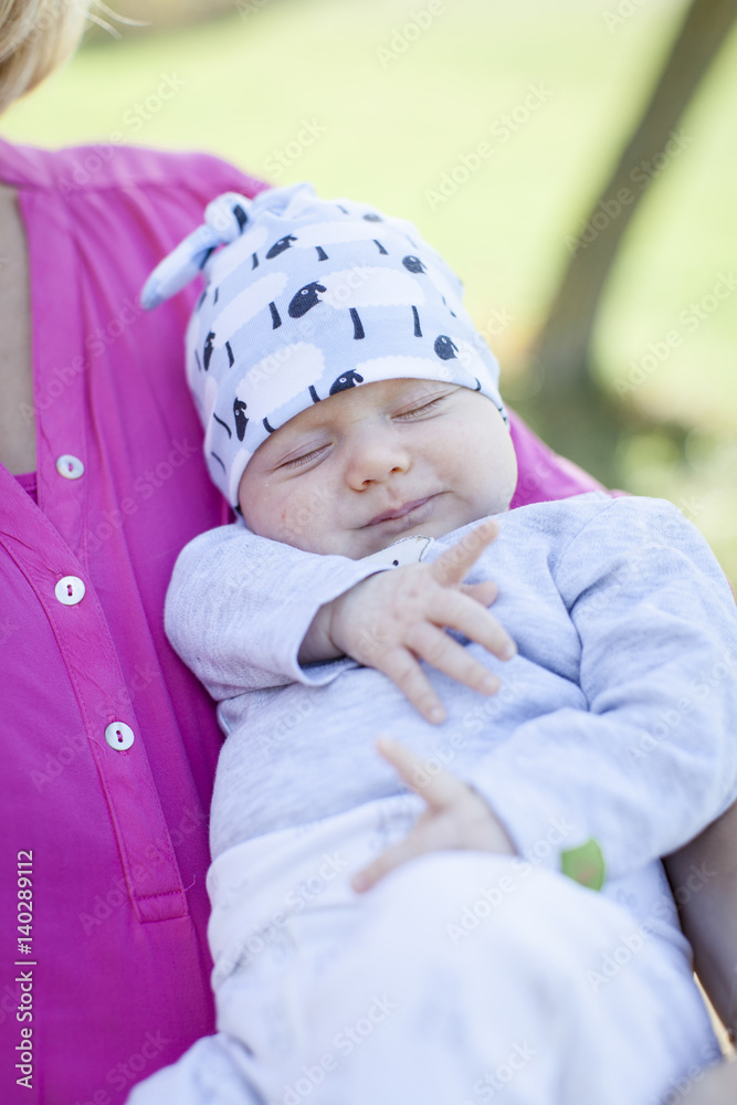 Wall mural young mother with newborn baby outdoors