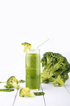 Healthy green cocktail, smoothies with spinach and broccoli in a glass glass, on a white wooden background