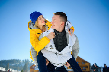 Young man holding his girlfriend on his shoulders