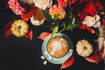 Cappuccino coffee and flowers composition on black background