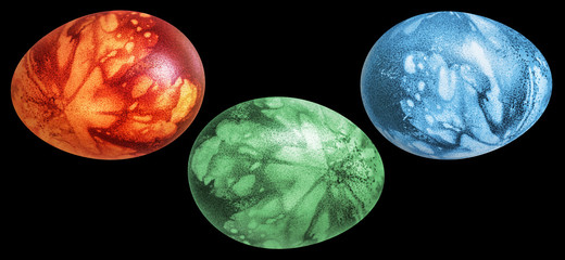 Obraz premium Three Colorful Easter Eggs Hand Painted and Decorated with Leaves Imprints Isolated on Black Background
