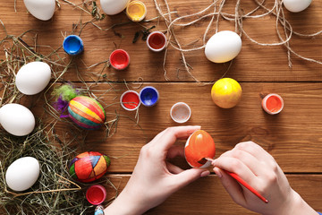 Painting colorful easter eggs, top view on wood