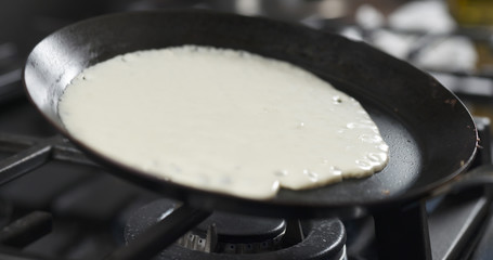 preparing blini or crepes batter pouring on hot pan, 4k photo