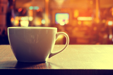 Cup of coffee on wooden table in cafe
