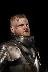Knight in armour after battle on the black background
