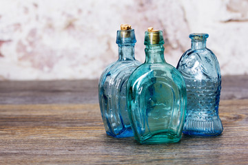 Coloured glass bottles on a rustic background