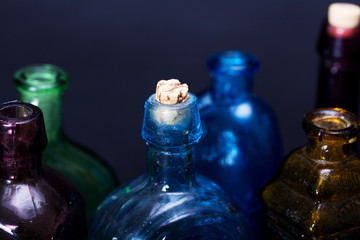 Old colourful bottles against a dark background