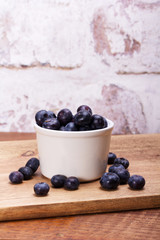 Pot of blueberries on a rustic background