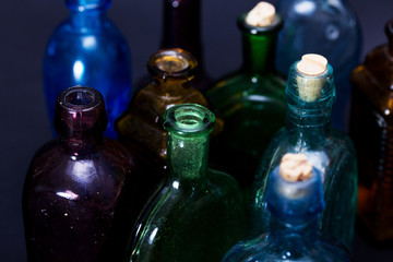 Old colourful bottles against a dark background