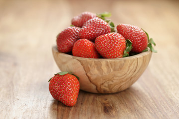 fresh strawberries in bowl on wood table, organic garden berries