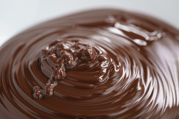 premium dark chocolate poured in bowl, shallow focus