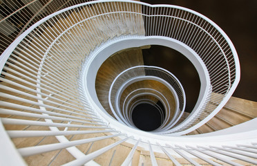 Spiral staircase in modern building with white railing