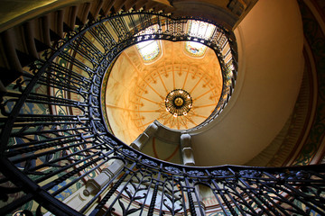 Spiral staircase in the hall with stained-glass window