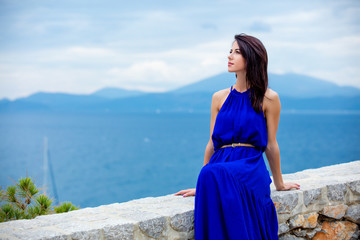 photo of beautiful young woman sitting on the stairs  in Greece