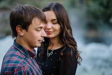 Fototapeta premium pair of beautiful brunette with a guy hugging on the nature