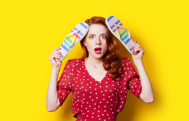 beautiful surprised young woman with colorful sandals on the wonderful yellow background