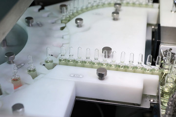 Sterile capsules for injection. Bottles on the bottling line of the pharmaceutical plant. Machine after checking sterile liquids. Interferon, nasoferon.