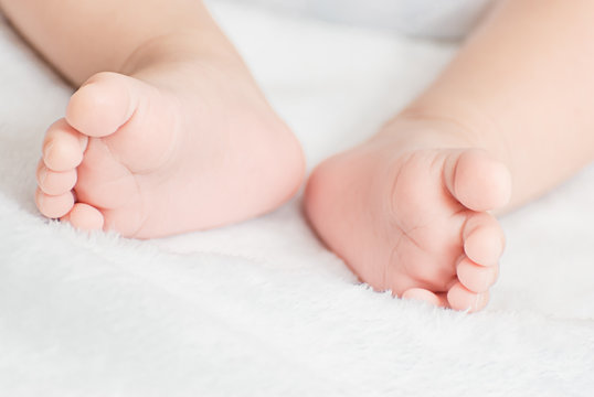 Close-up of mother hands holding tiny baby feet