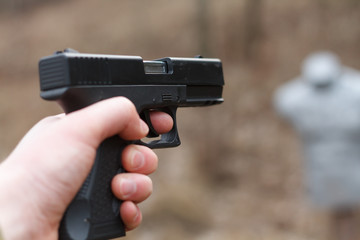 Shooting from a pistol. Reloading the gun. The man is aiming at the target. Shooting range. Man firing usp pistol at target in indoor shooting range