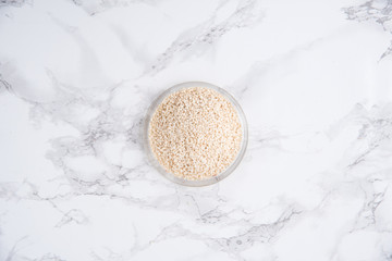 Top view of white sesame in a bowl isolated on white