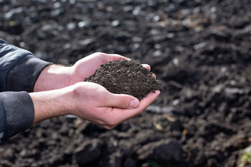 Farmer holding soil in hands in field