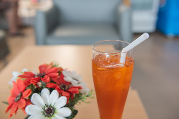 cold ice tea in glass and flower in restaurant.