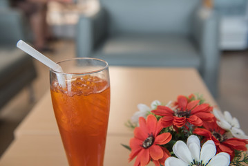 cold ice tea in glass and flower in restaurant.
