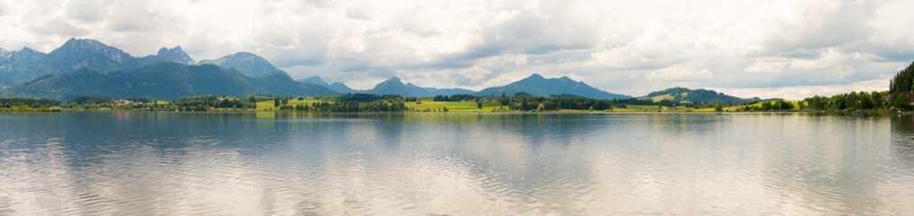 Panorama mountain lake with mountains in the mist on the horizon