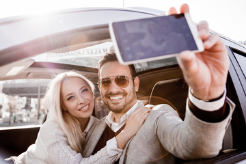 Happy young couple in their new car