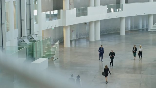 High angle of business people walking in hall of large corporate building