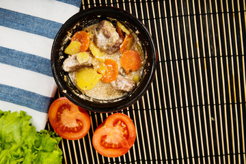 Beef meat stewed with potatoes, carrots and spices in ceramic pot