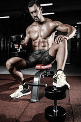 Caucasian sexy fitness male model execute exercise with dumbbells