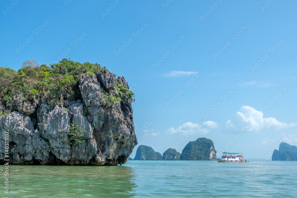 Wall mural unidentifiable tour boat cruising in phang nga bay, thailand