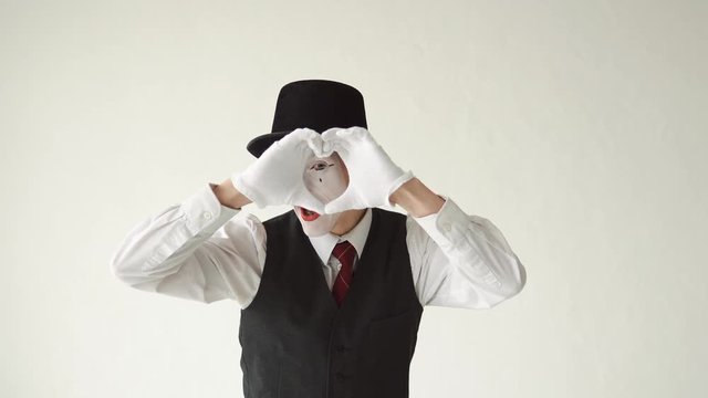 romantic MIME on a white background. MIM looks at the camera and shows hearts