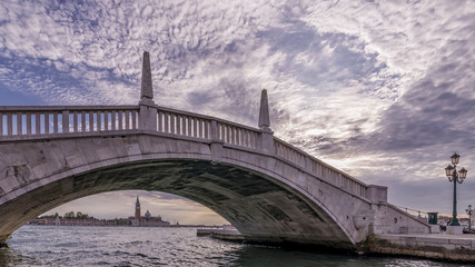 Fototapeta na wymiar A typical Venetian bridge, Ponte San Biasio delle Catene, in the historic center of Venice, Italy, under which you can see the island of San Giorgio Maggiore