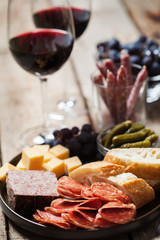 Red wine with charcuterie assortment on the background