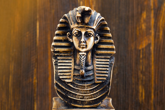 Souvenir sculpture of the Egyptian pharaoh on the wooden background