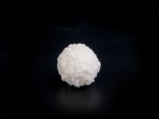 Raffaello white candy with coconut flakes on a black background