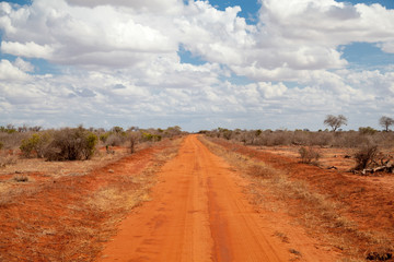 Red soil way, blue sky with clouds, scenery of Kenya


