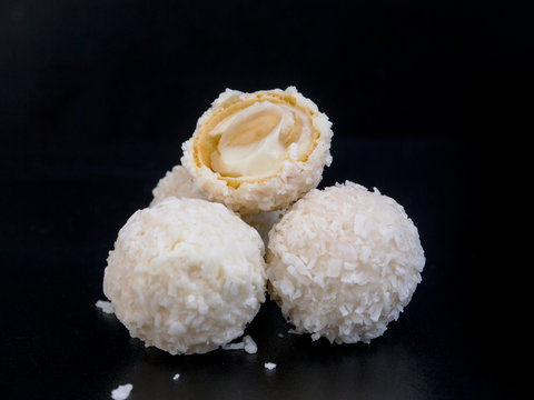 Raffaello white candy with coconut flakes on a black background