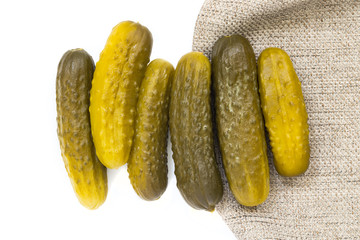 Pickled cucumbers on white isolated background with gray cloth texture