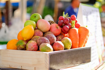 Various fruits in wooden basket on market organic vegetables.