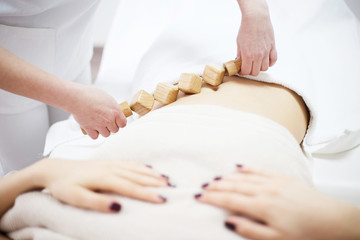 Anti cellulite massage for young woman with rolling pins