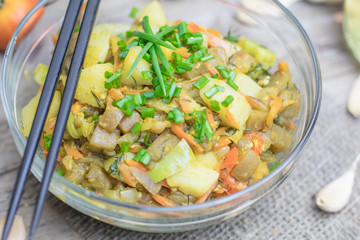 Homemade nutritional vegetable ragout in glass plate bowl on rustic old wooden table. Vegan or vegetarian food diet. Selective focus.